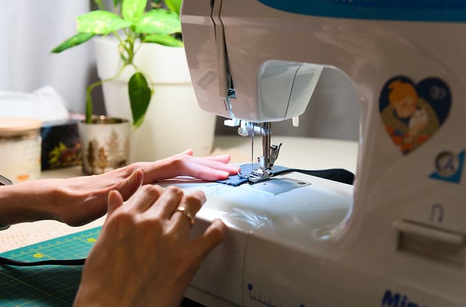 image of hands and sewing machine
